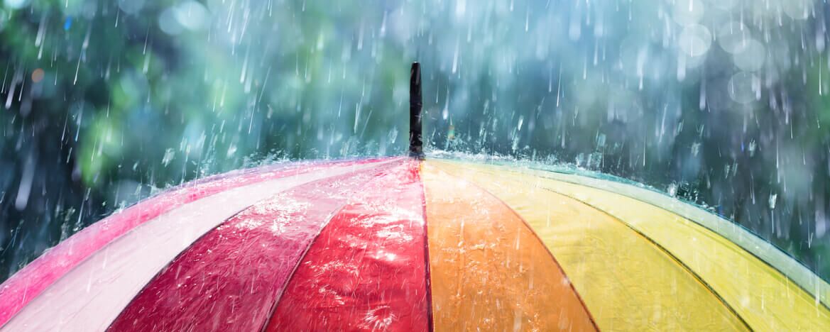 Colourful umbrella in pouring rain