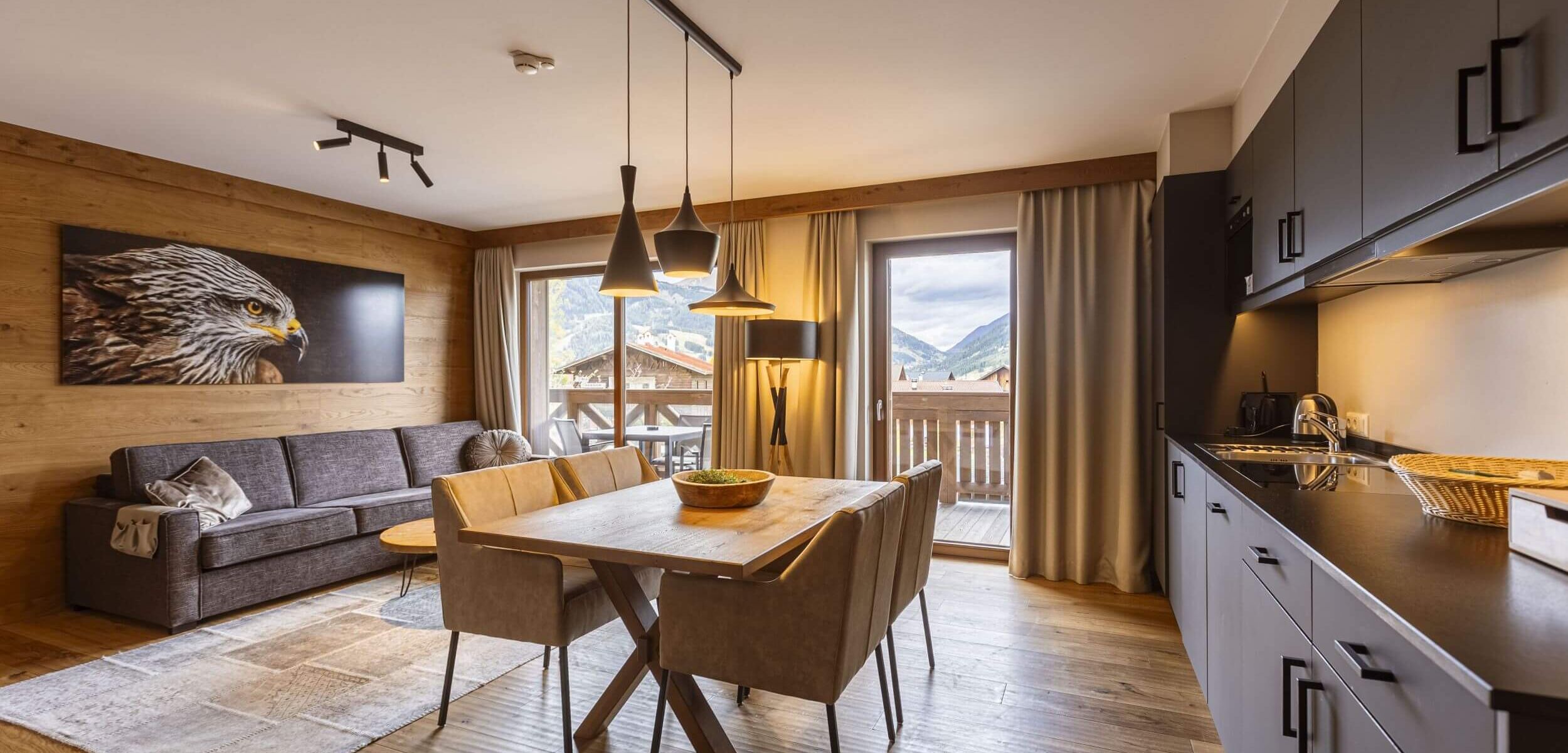 Moderne Ferienwohnung in Tirol mit stilvoller Einrichtung, bequemer Couch, Esstisch, Küche und Adler Wanddekoration