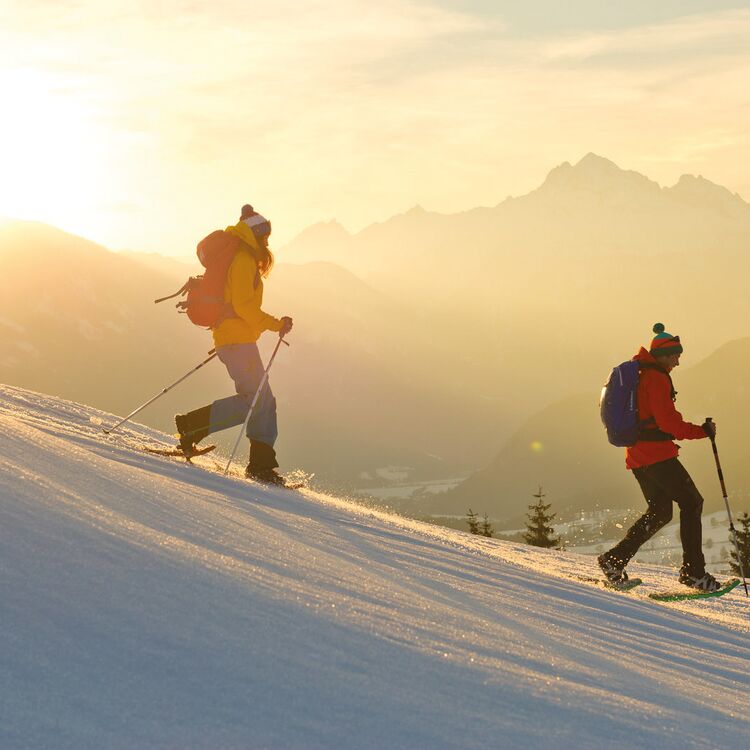 Snowshoe hike at sunset through the snowy winter landscape around the Leppneralm.