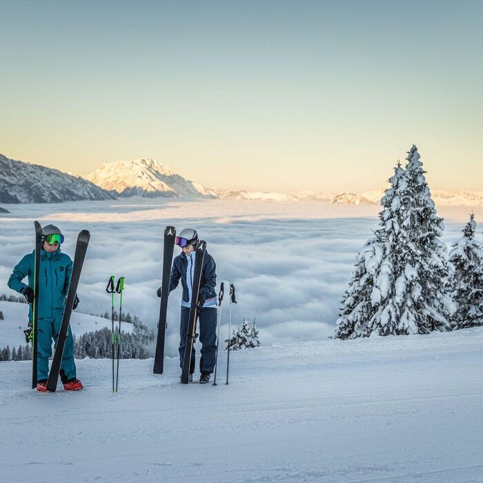 Skifahrer am Dachstein mit Sonnenaufgang und Blick auf die Berge