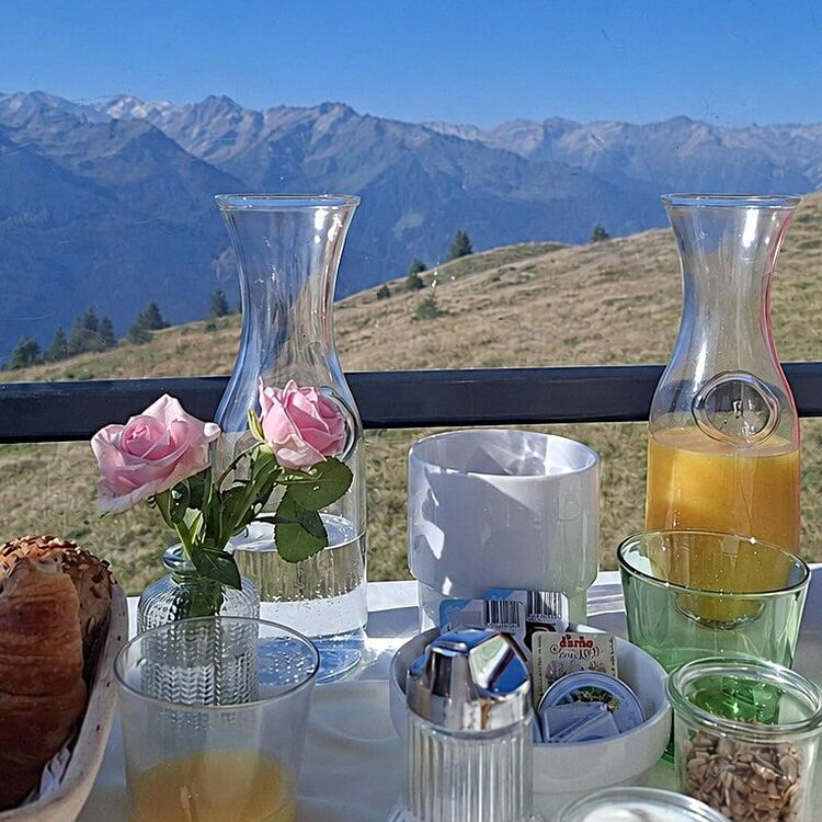 Ein Gondelfrühstück mit frischen Brötchen und Blick auf die majestätischen Berge in der Ferne.