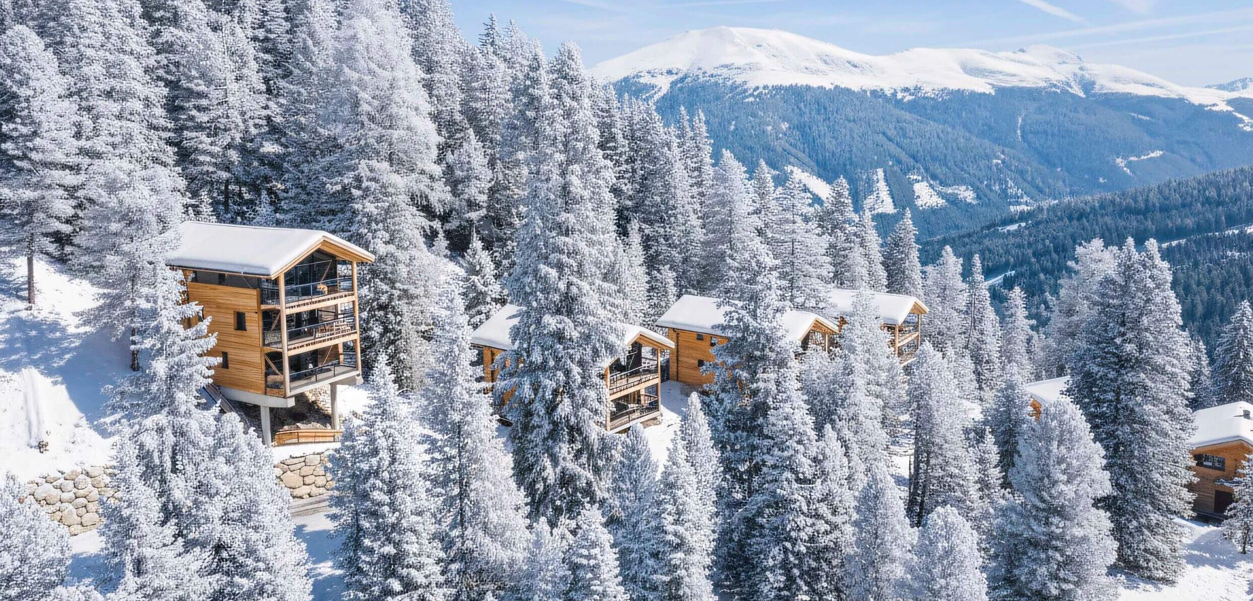 Ferienhäuser inmitten des winterlichen Zirbenwaldes auf der Turracher Höhe