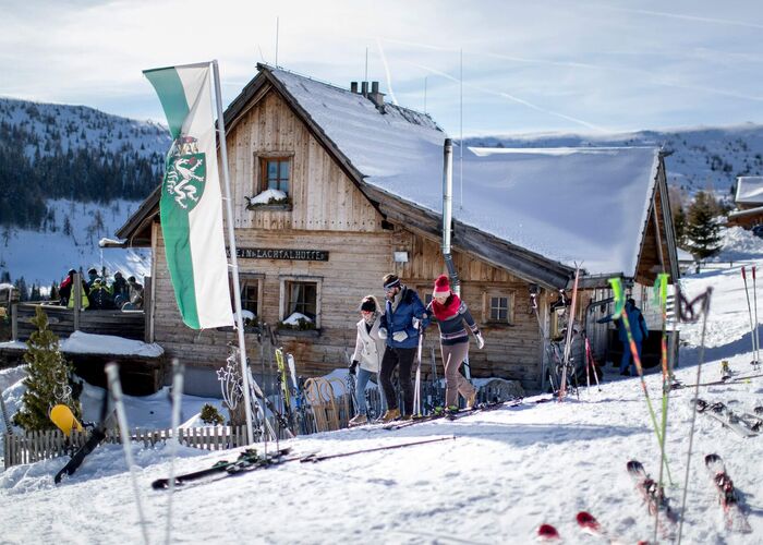 Skihütte im Skigebiet Lachtal mit Flagge der Steiermark und abgestellten Skiern