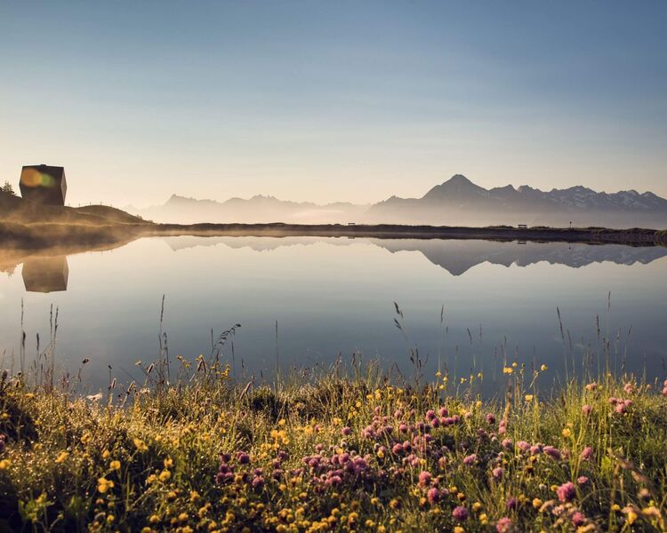 Ruhiger Bergsee im Zillertal in herbstlicher Stimmung, umgeben von alpiner Bergkulisse.