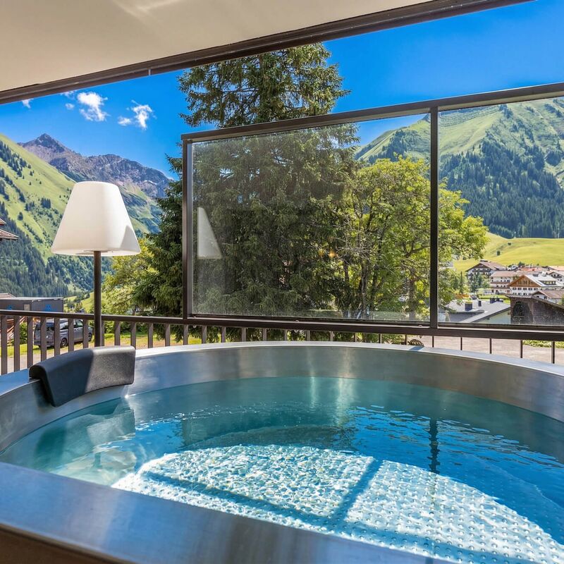 Private outdoor tub on the balcony of an apartment at Bergresort Berwanger Hof with mountain views