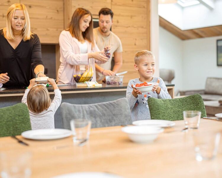 A family with children is preparing a simple meal in their holiday apartment.