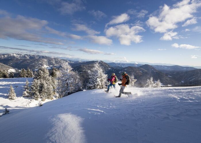 Verschneites Bergpanorama auf der Frauenalpe in Murau in der Steiermark während einer winterlichen Schneeschuhwanderung.