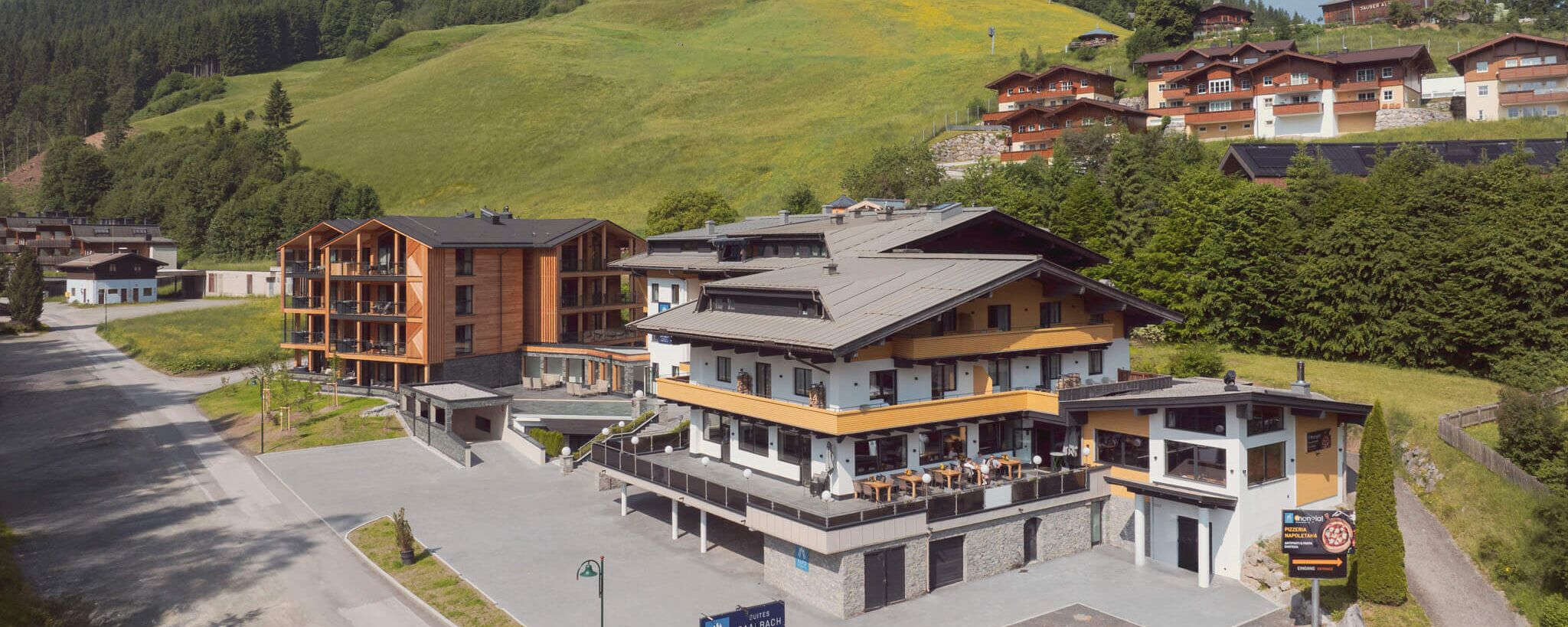 Gesamtansicht der Saalbach Suites in Saalbach Hinterglemm im Sommer vor der alpinen Berglandschaft