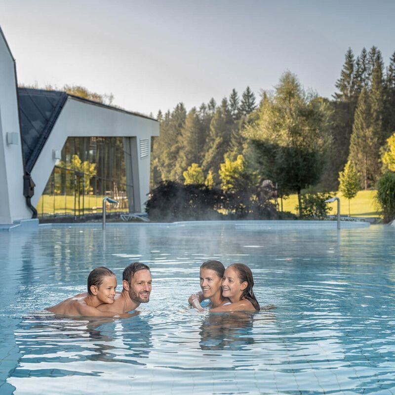 Family in an outdoor pool of a thermal spa