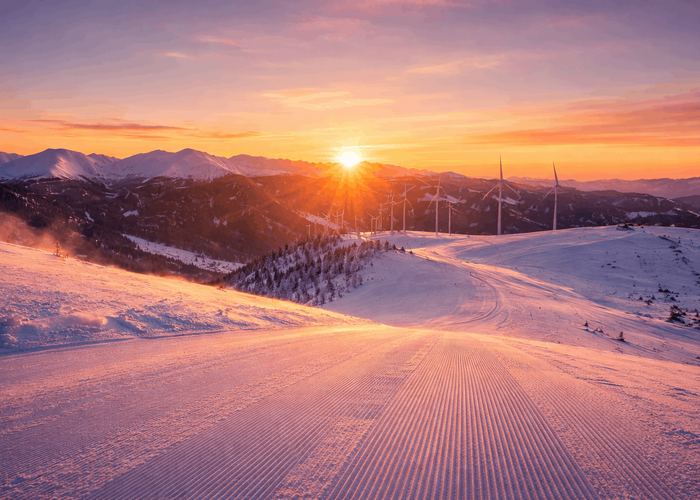Skifahren am frühen Morgen im Lachtal bei Sonnenaufgang mit Blick auf die verschneite Berglandschaft.