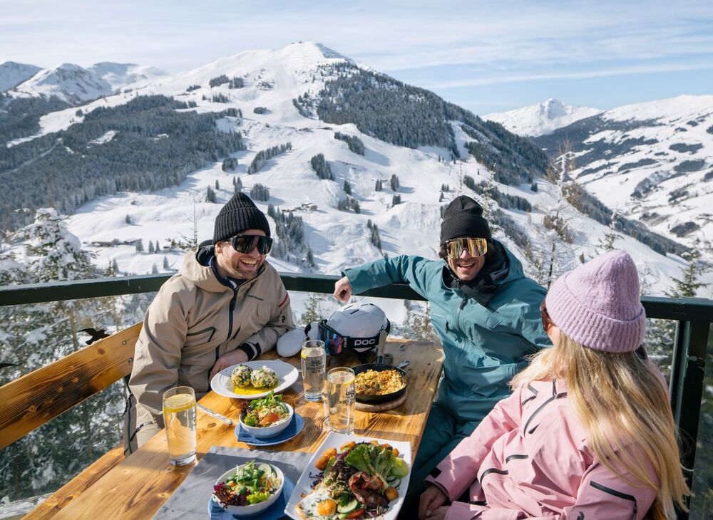 Freunde essen typisch regionale Speisen auf der Skihütte