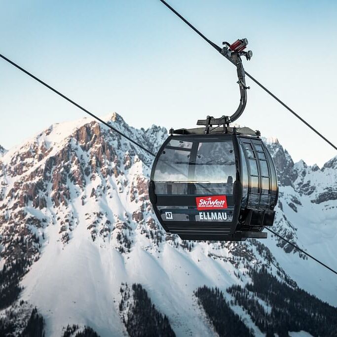 Modern gondola lift in front of an impressive summit panorama
