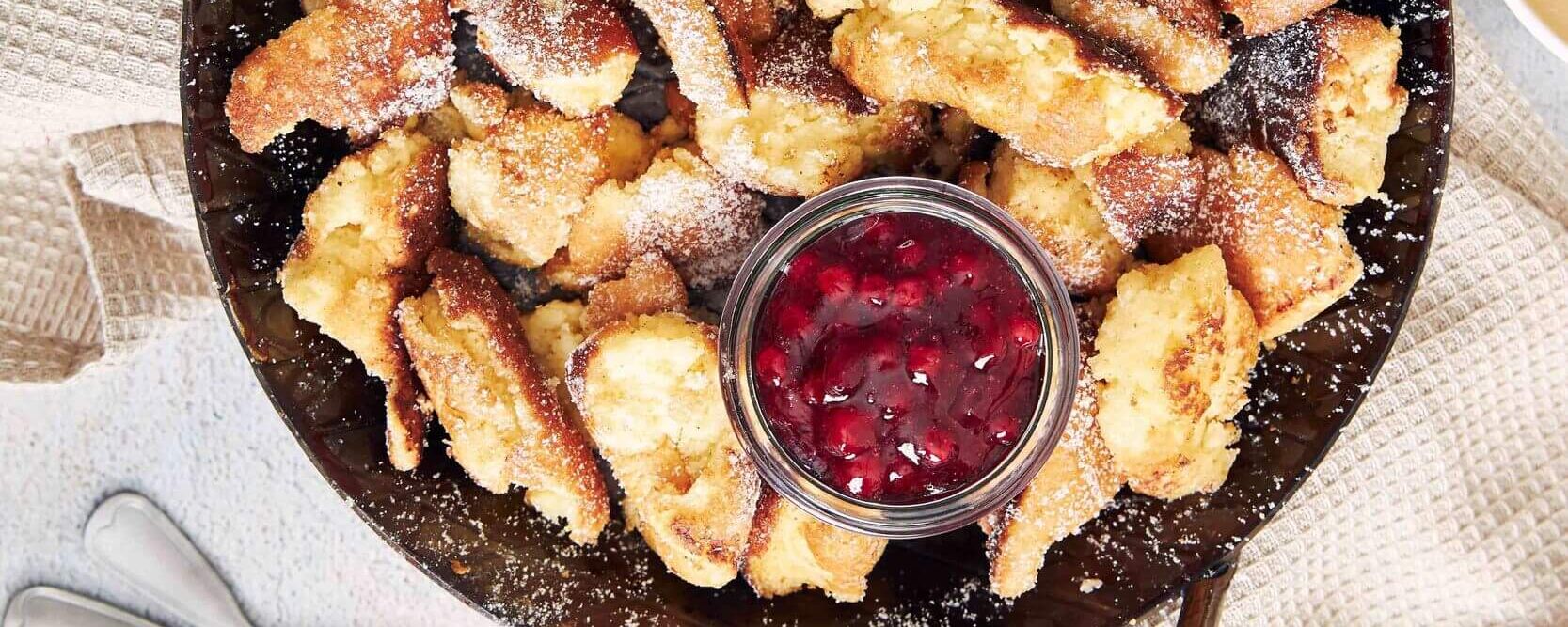 Fluffy Kaiserschmarrn topped with jam and powdered sugar