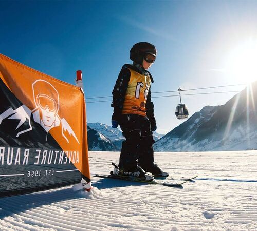 Kind bei seinen ersten Versuchen auf Skiern im flachen Kinderübungsgelände