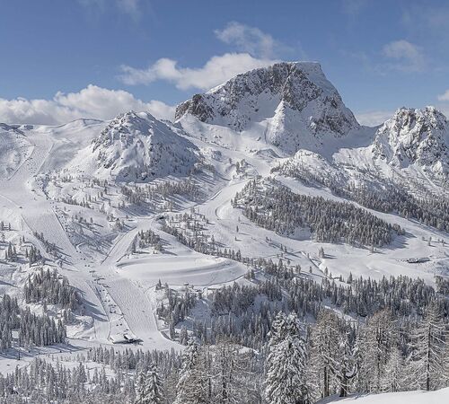 Schneebedeckte Berglandschaft mit Skipisten und Skiliften am Nassfeld in Kärnten