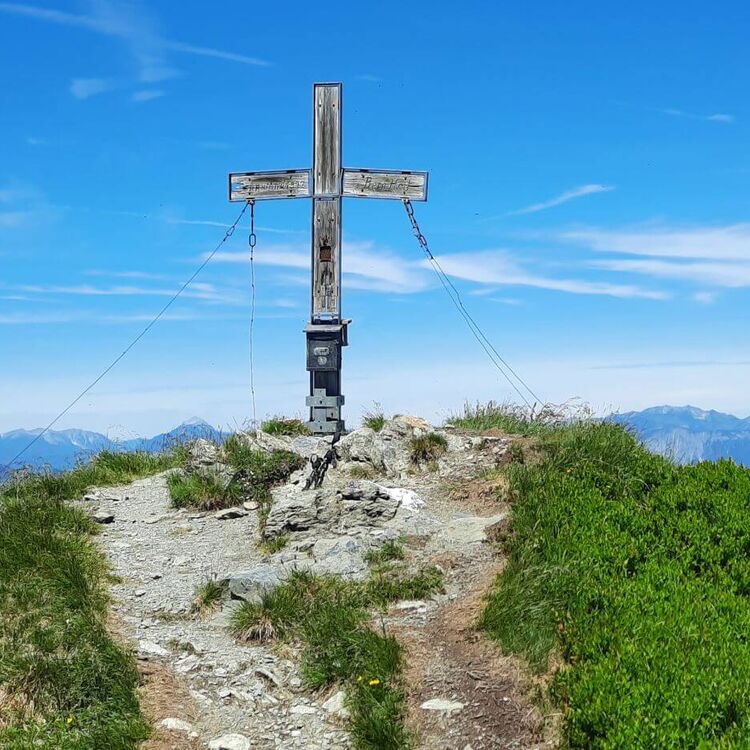 Gipfelkreuz am Brechhorn mit Blick auf die Tiroler Alpen