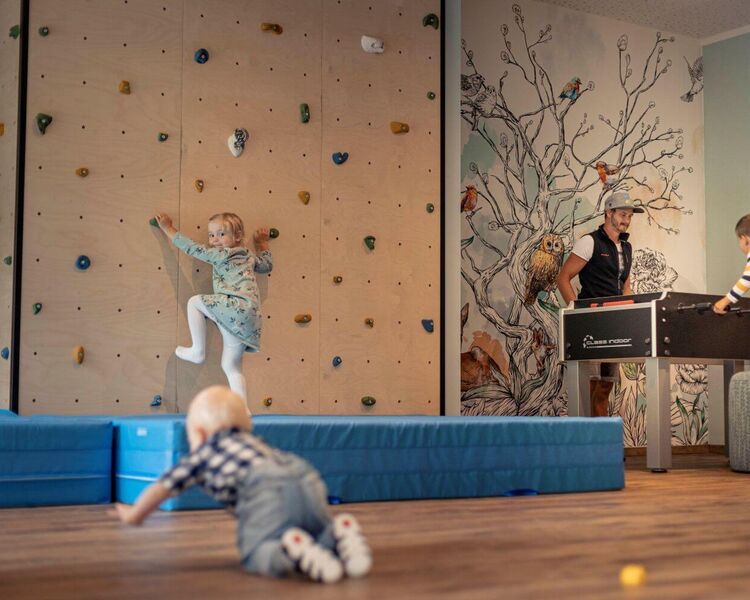 Kinder klettern, krabbeln und spielen Tischfußball im Spielraum eines Aparthotels