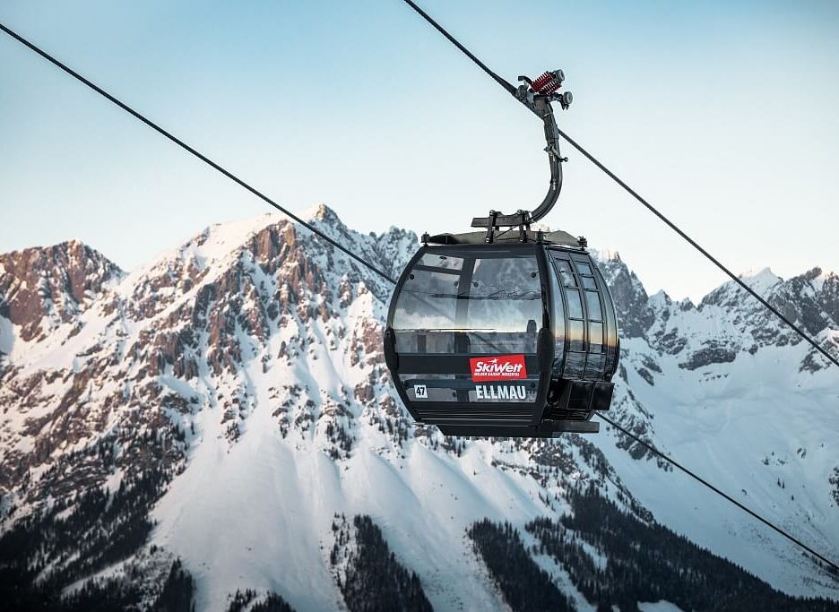Moderne Gondelbahn vor einem gewaltigen Gipfelpanorama