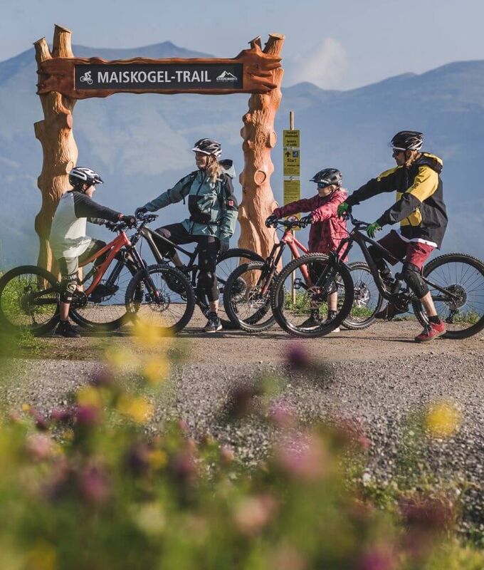 Familie mit 2 Kindern mit ihren Bikes am Start eines Bike Trails.
