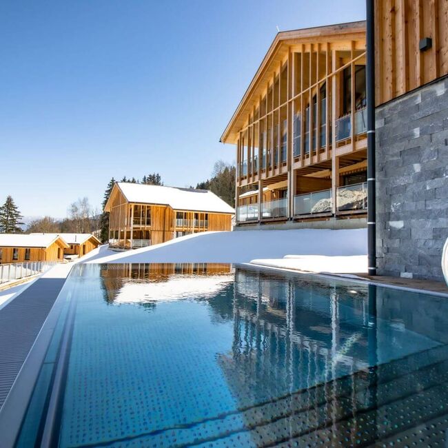 Moderne, schneebedeckte Chalets mit privatem Outdoor Pool.