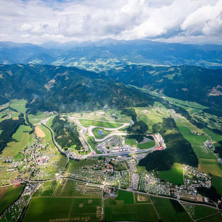 Luftaufnahme der Rennstrecke in den Bergen, umgeben von malerischer Landschaft und kleinen Dörfern. | © Name