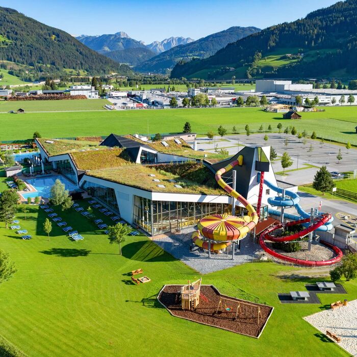 Luchtfoto van Erlebnis-Therme Amadé in Altenmarkt im Pongau met binnen- en buitenzones, omgeven door het berglandschap van SalzburgerLand.