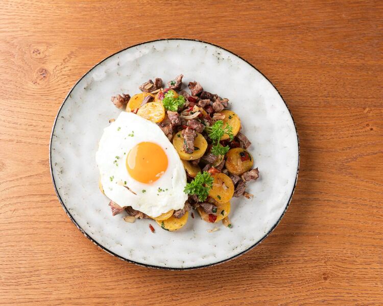 Bord met Tiroolse Gröstl en gebakken ei op een keukentafel