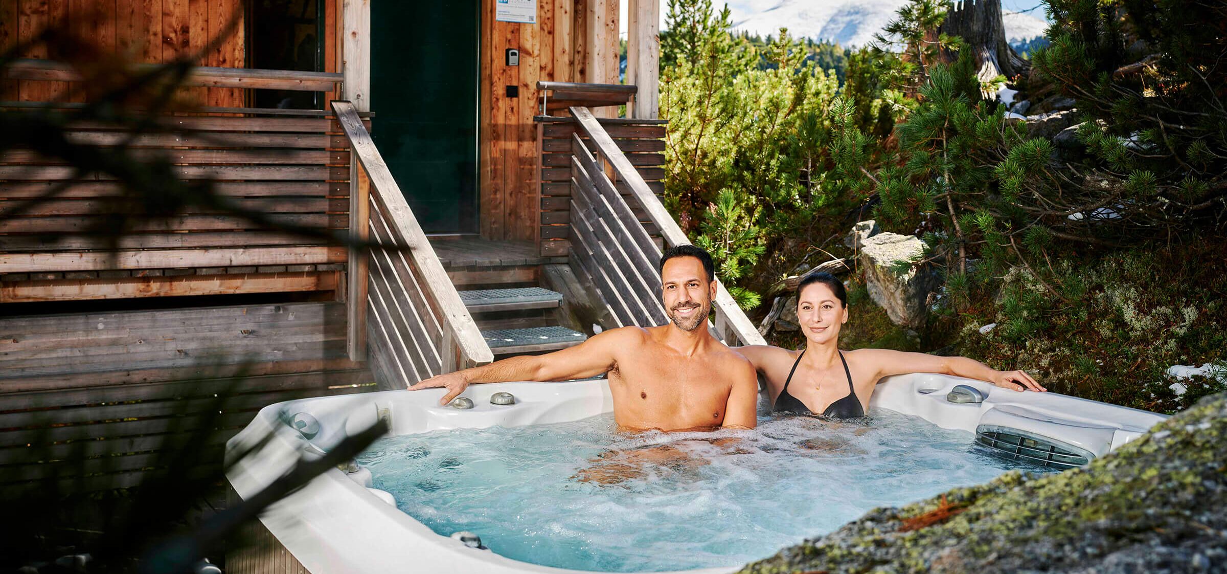 People sitting in a whirlpool of a chalet in autumn