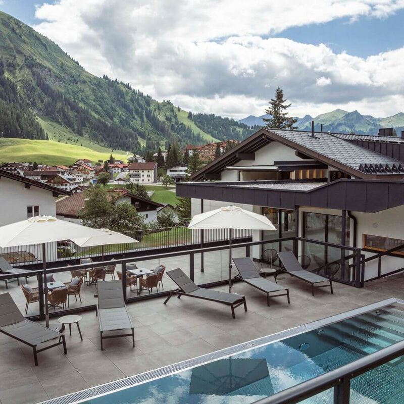 Terrace of an aparthotel in the mountains with outdoor pool and sun terrace