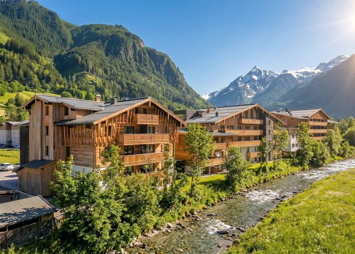 Außenansicht des Carpe Solem Kaprun im Sommer, umgeben von grüner Landschaft und der beeindruckenden Bergwelt rund um Kaprun.