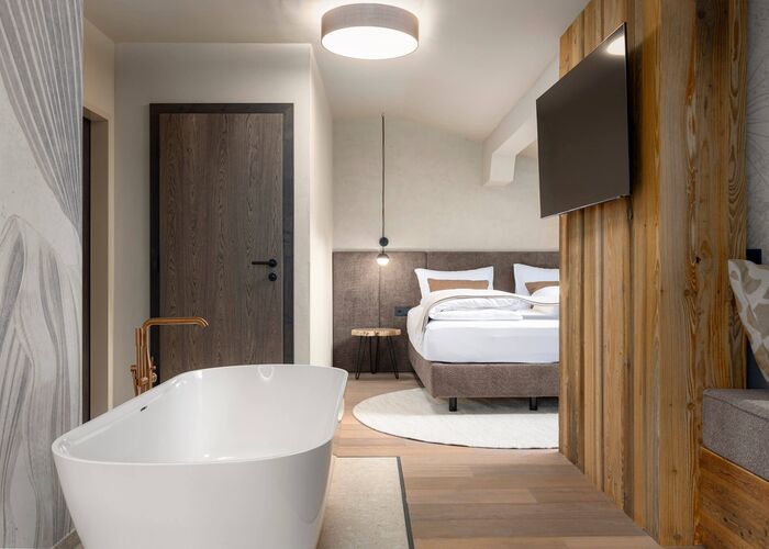 Freestanding bathtub and modern double bed at the Hotel Carpe Solem Kaprun