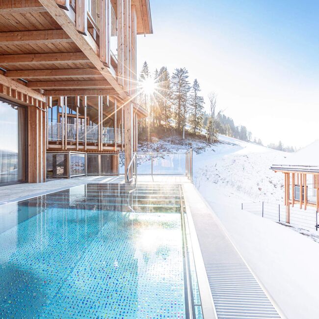 Sonne scheint auf kristallklares Wasser im privaten Pool auf der Terrasse des Ferienhauses