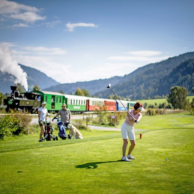 Golfer on the golf course, the Murtalbahn in the background