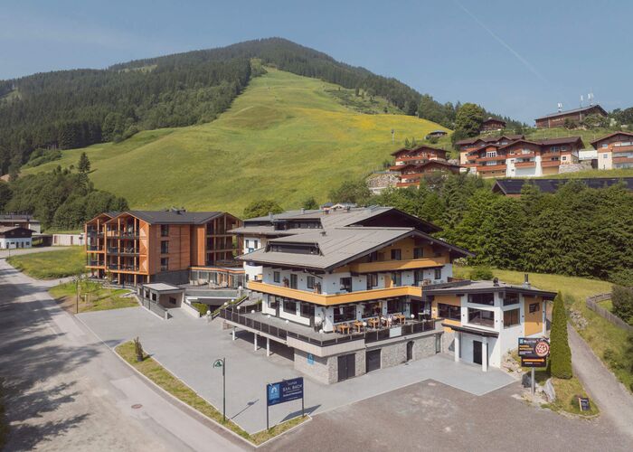 Gesamtansicht der Saalbach Suites in Saalbach Hinterglemm im Sommer vor der alpinen Berglandschaft