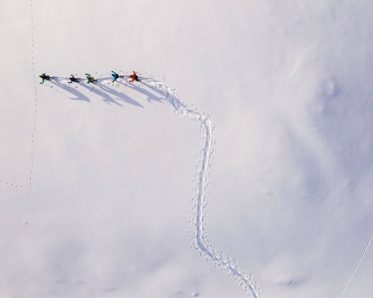 erial view of snowshoe hikers crossing the snowy winter landscape of the Raurisertal
