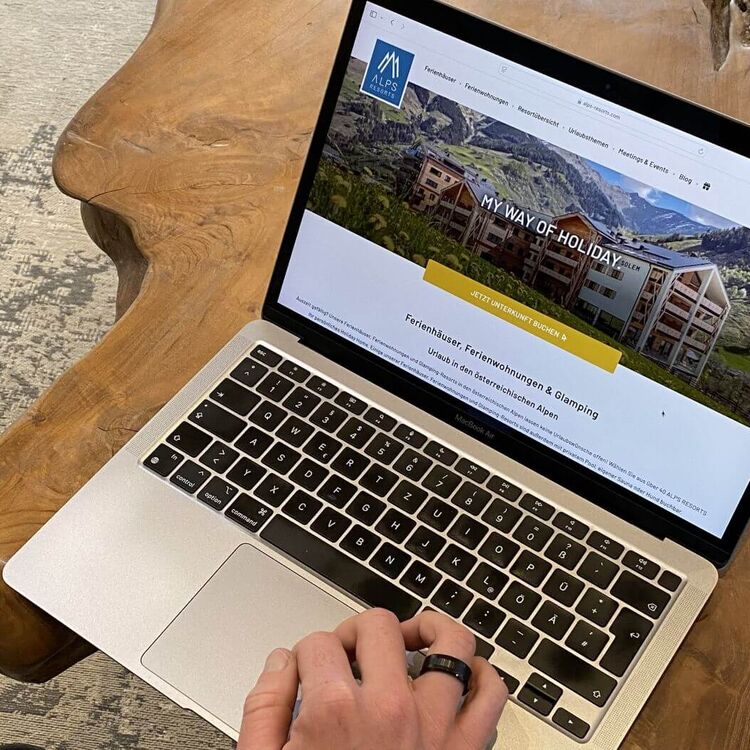 Auf einem Laptop sucht jemand die passende Ferienunterkunft bei ALPS RESORTS.