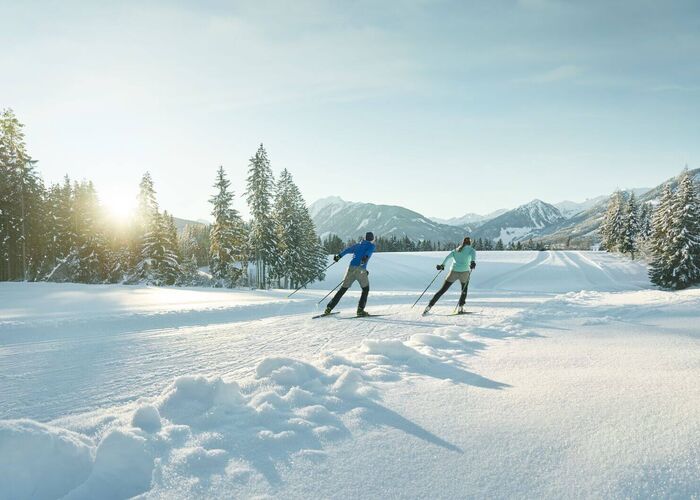 Twee langlaufers op een perfect geprepareerde loipe in een sprookjesachtig winterlandschap