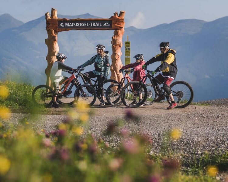 Family with two children and their bikes at the start of a bike trail.
