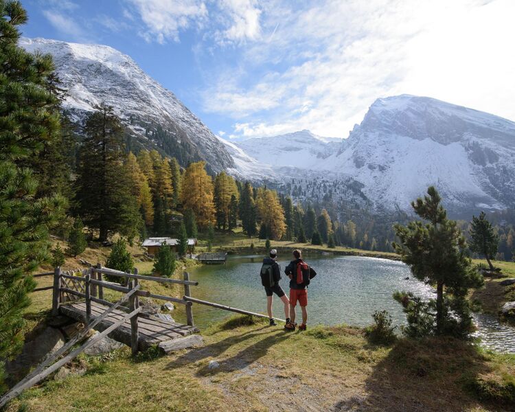 Hiking by a mountain lake in the Zillertal surrounded by vibrant autumn colours.