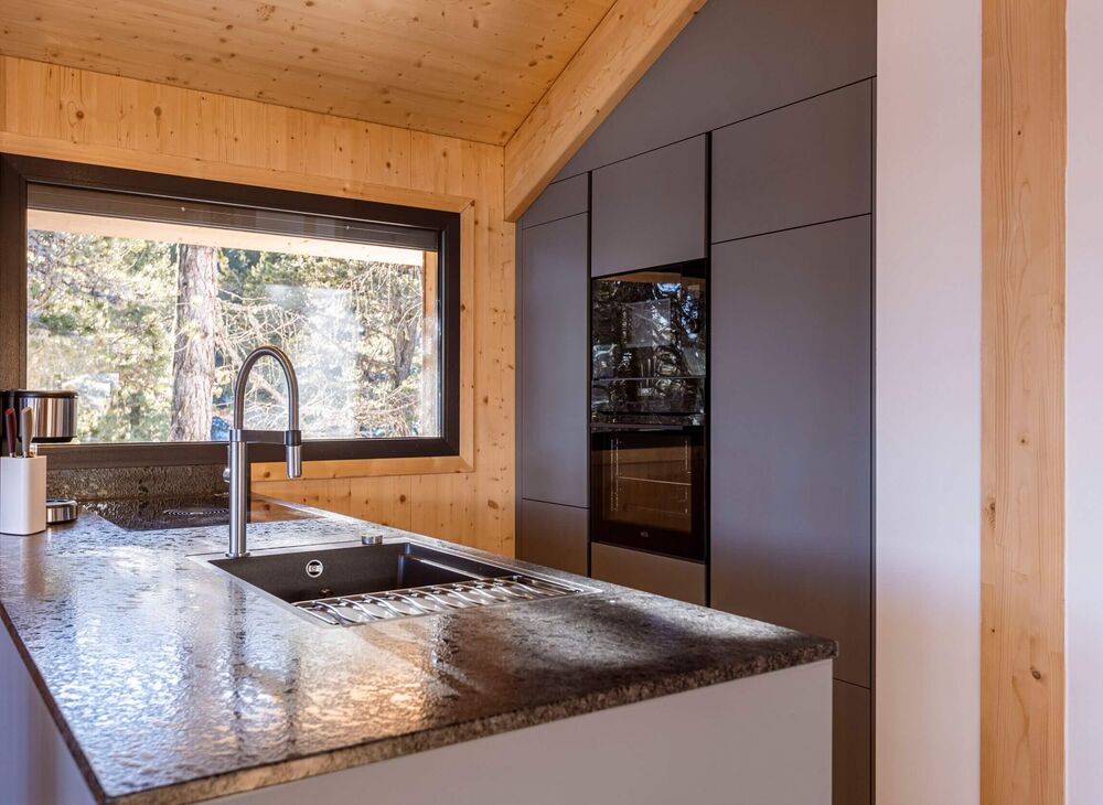 Modern kitchenette with coffee machine, oven and microwave