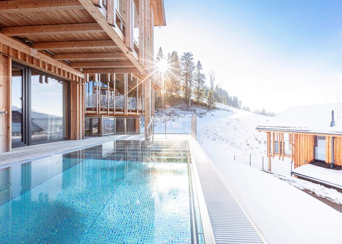 Sonne scheint auf kristallklares Wasser im privaten Pool auf der Terrasse des Ferienhauses