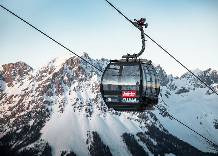 Modern gondola lift in front of an impressive summit panorama