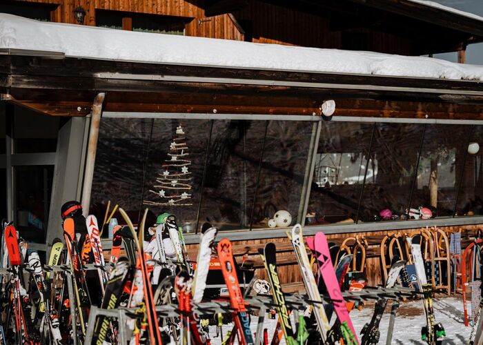 Skis and sledges in front of a mountain restaurant on the Bergeralm