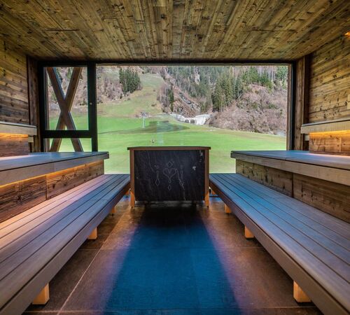 Moderne, private Sauna mit großem Panoramafenster und Ausblick auf die Berglandschaft von Salzburg