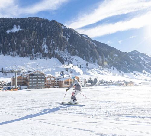 Ski in/Ski out: Skifahrerin auf der Piste zum Carpe Solem Rauris