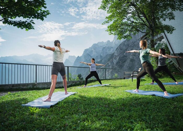 Yoga am Berg mit mit Blick auf die Berge im Hintergrund