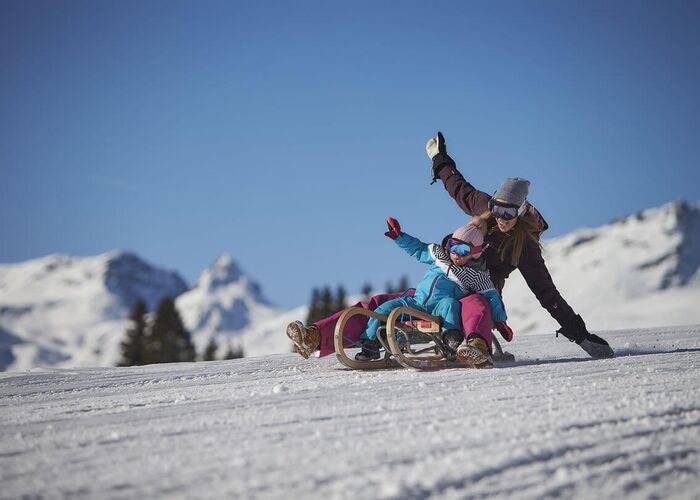 Two people on a toboggan in Saalbach Hinterglemm