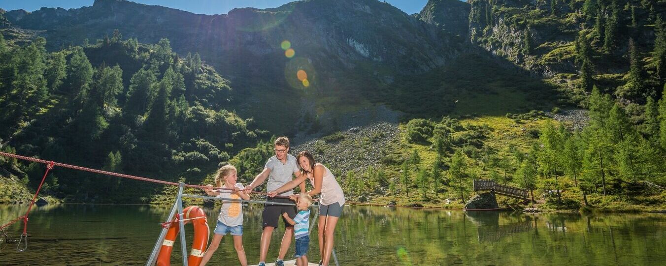 Familie fährt mit einem Floß über den Untersee in Schladming