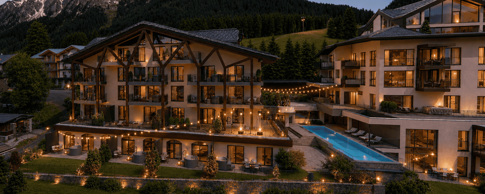 Beleuchtete Außenansicht des Bergresort Berwanger Hof am Abend mit Außenpool und Blick auf die umliegende Berglandschaft.