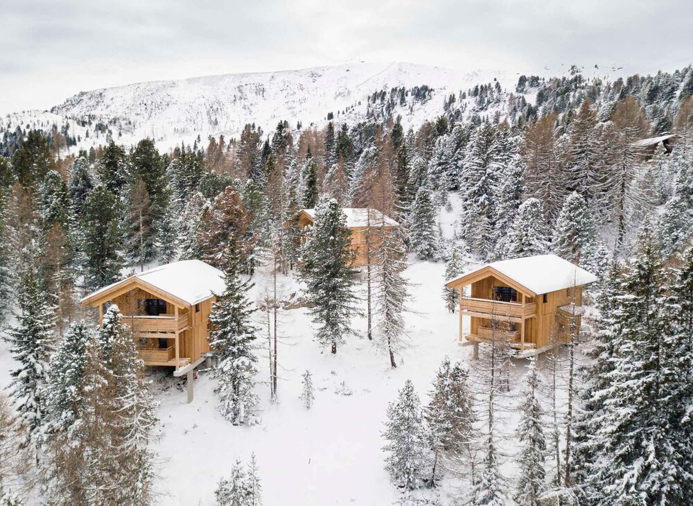 Ferienhäuser aus Holz im winterlichen Zirbenwald auf der Turracher Höhe